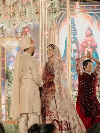 A closer look at the couple during the Varmala ceremony, framed by dancers performing a traditional welcome. The coordination of entertainment and rituals is a key part of my planning process.