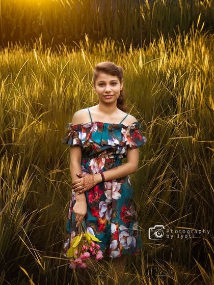 A portrait of a young girl standing in a field of tall, golden wheat at sunset. The warm light and natural texture create a beautiful, artistic feel.