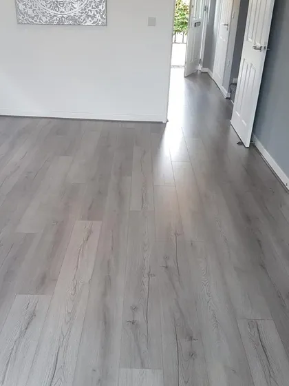 For a clean, contemporary look, I often recommend this style of light grey wood-look flooring. It provides a neutral and bright foundation that works with any decor, making this hallway feel open and modern. This is a great dust-free flooring solution for busy households.
