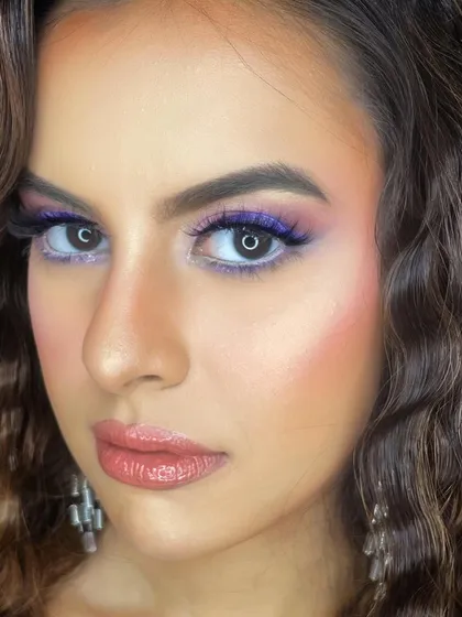 A close-up showing the detailing of the evening glam look, with a pop of purple under the eye for an unexpected touch of color.