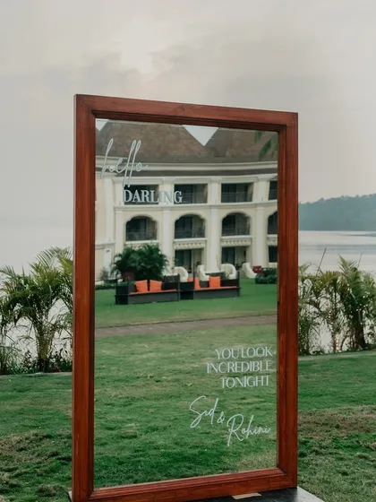 A thoughtful detail for guests. This large, framed mirror with the message "Hello Darling, You look incredible tonight" adds a personal and interactive touch to the event decor, reflecting the beautiful Goa venue.