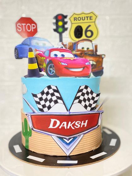 Kachow. A Lightning McQueen cake for a fan's 6th birthday. This pineapple cake features the whole Cars crew, traffic signals, and a racetrack design.