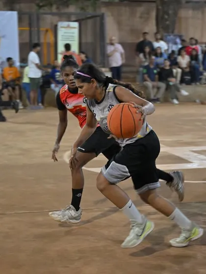 Fierce competition in our women's division. A player drives past the defense for a tough layup, showcasing the skill and intensity of our women's games.