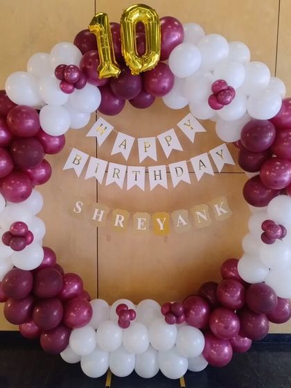 A simple yet elegant circular balloon frame in maroon and white for a 10th birthday.