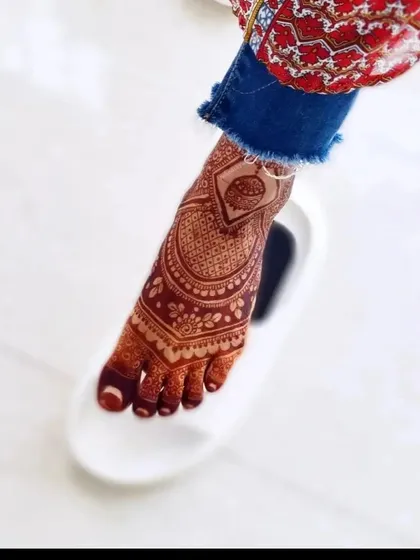 A fun and memorable shot of a bridal foot mehndi. It's all about capturing the happy moments.