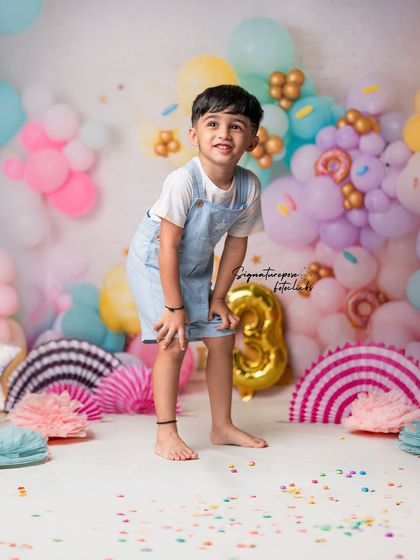 A candid shot from the third birthday celebration, capturing the boy's playful energy and excitement amidst the colorful party decorations.