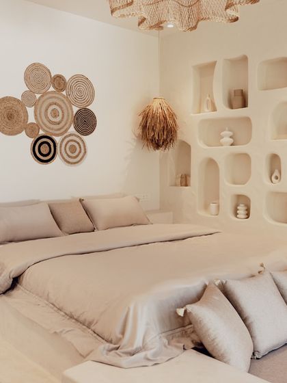 The bedroom is a sanctuary of calm, featuring a built-in bed platform and organic shapes in the wall niches. I used a monochrome palette of beige and cream, with natural fiber lighting and wall decor to enhance the restful, earthy atmosphere.