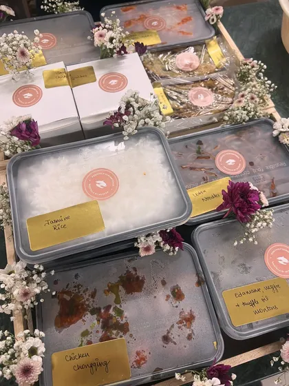 A Mother's Day meal gift, beautifully decorated with fresh flowers. This order included Chicken Chongqing, Edamame Truffle Fried Rice, and other gourmet dishes.