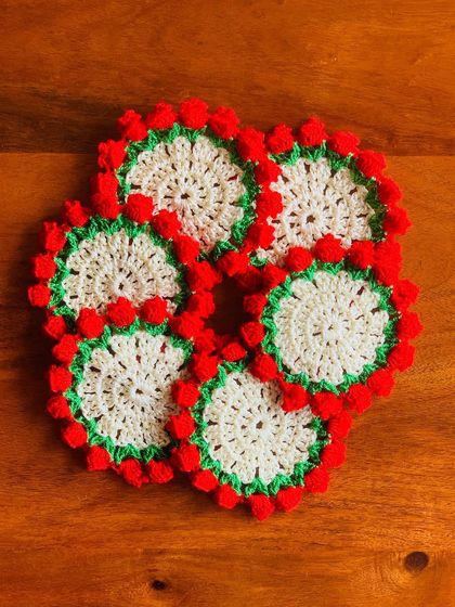 A set of matching coasters with a cream center and red tulip border.