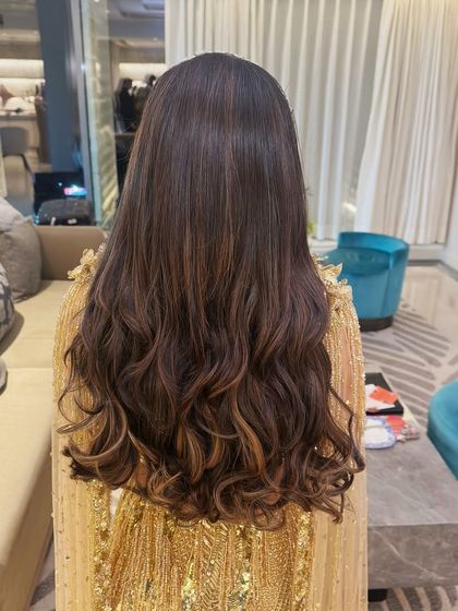 A timeless glam look featuring soft waves pulled back into a simple half-up style, accented with a sparkling headband.