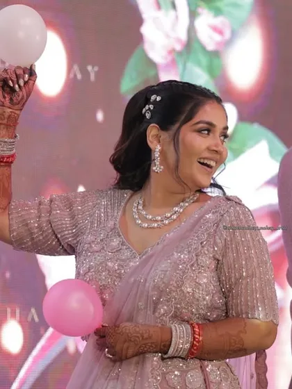 A fun, candid shot from a sangeet. Her makeup remains flawless and radiant even while she's enjoying the party games and celebrations.