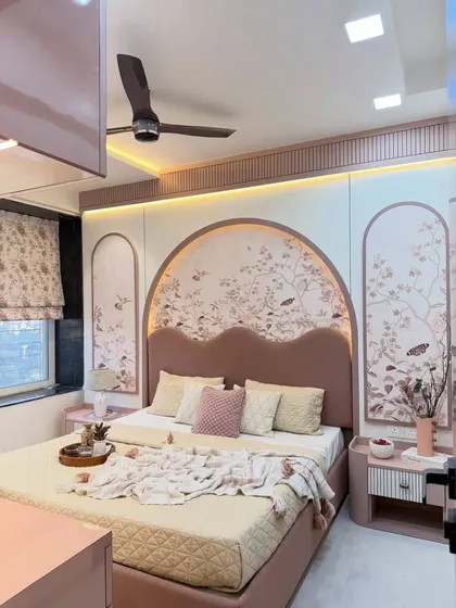 We love creating personalized bedrooms that reflect our client's personality. This room features a custom-arched headboard with floral wallpaper and integrated lighting, creating a soft, romantic focal point. The dusty rose and cream color palette, combined with matching side tables and wardrobes, makes this a truly unique and serene personal escape.