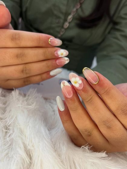 A soft and delicate French manicure with a floral twist. This design features a classic white tip with a sheer base, accented with a single, translucent hand-painted flower.