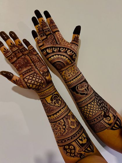 A full-arm design with a mix of traditional Indian motifs, including paisleys, elephants, and intricate line work.