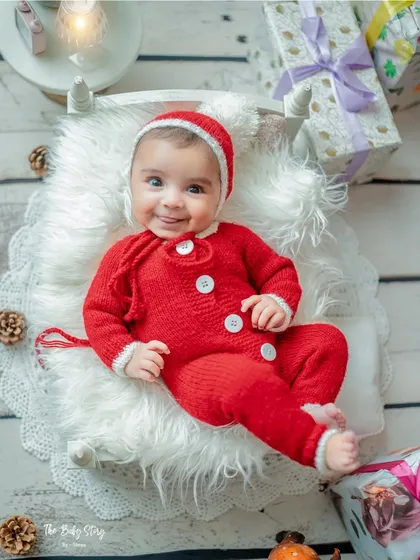 A big, gummy smile from this adorable newborn. This photo is pure happiness and a perfect memory of baby's first Christmas season.