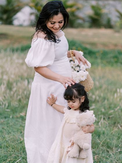 A mother and daughter walking through a field. The soft light and natural setting create a dreamy, poetic image.
