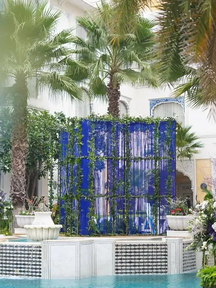 A view across the pool, showing a large blue backdrop made of hanging tassels. This created a beautiful screen of color against the palace architecture.
