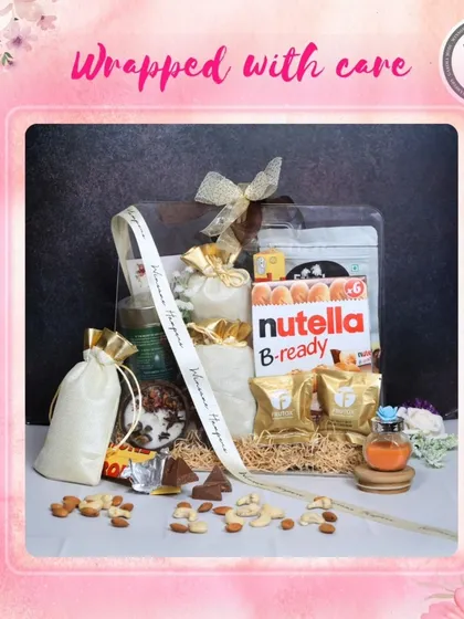 A hamper wrapped with care, ready to be gifted for any special occasion. This clear-lidded box is filled with Nutella B-ready, almonds, scented candles, and other treats, all nestled in shredded paper and tied with my signature ribbon.