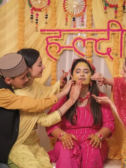 Family members lovingly apply Haldi to the bride, a heartwarming and traditional moment.