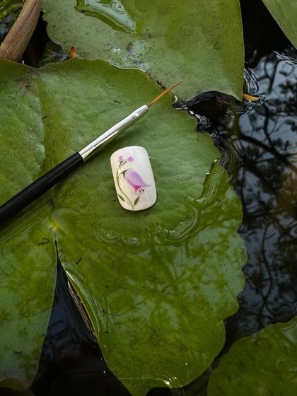Fancy some floral art? This shows a sample nail with a beautifully hand-painted pink flower, showcasing the creativity of my technicians.