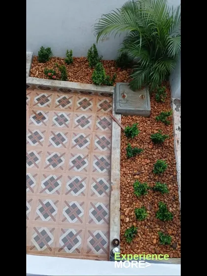 This is a bird's-eye view of a compact garden bed I created in a small courtyard. By using a border, red pebbles for ground cover, and carefully placed shrubs, I turned an unused corner into a neat and attractive feature.
