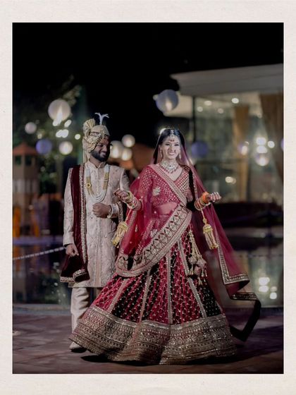 A full-length portrait of the couple walking hand-in-hand at night, the venue's lights creating a romantic ambiance.