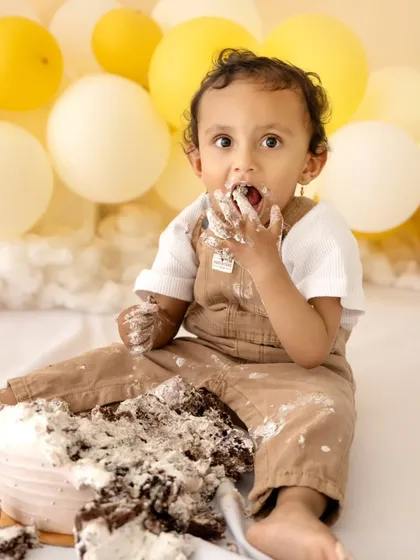 It's time for a cake smash. This close-up shot captures the hilarious and sweet moment a baby gets to enjoy their first taste of birthday cake with pure delight.