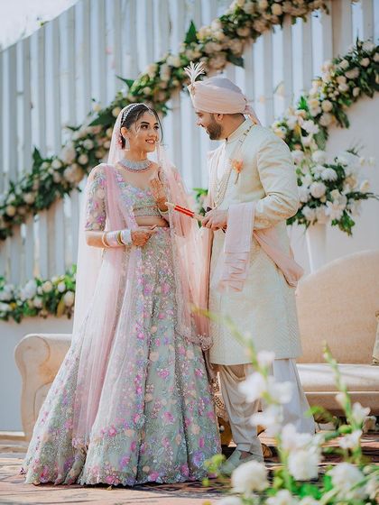 The couple shares a look during their wedding ceremony, with a beautiful floral arch in the background.