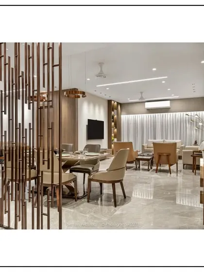 This image showcases an open-plan living and dining area where a decorative metal partition creates a subtle separation without closing off the space. The consistent use of materials and a neutral color palette ensures a harmonious flow throughout.