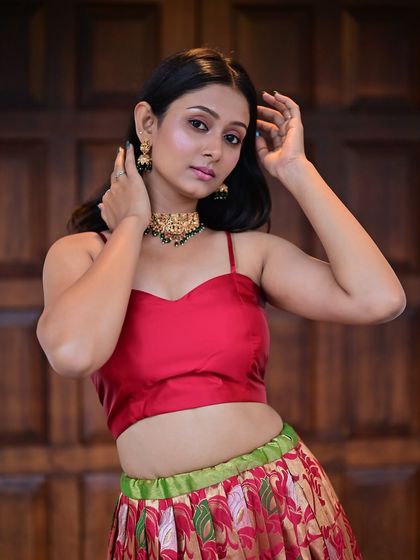 A model in a red crop top and printed skirt.