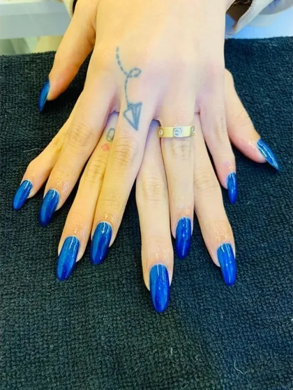 Make a bold statement with this vibrant royal blue. This look features perfectly shaped, long almond nails coated in a high-gloss, solid blue gel polish for a clean, striking, and confident finish.