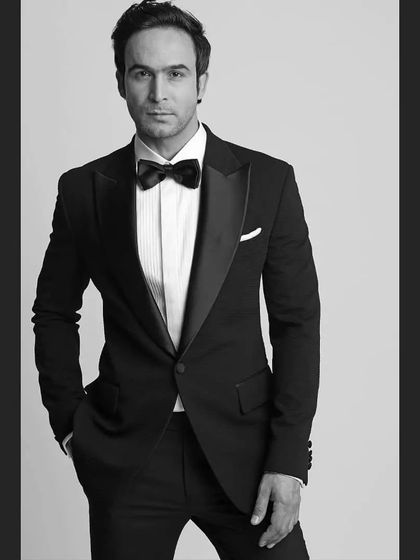 A black and white portrait of a model in a classic tuxedo. The timeless appeal of this outfit is undeniable.