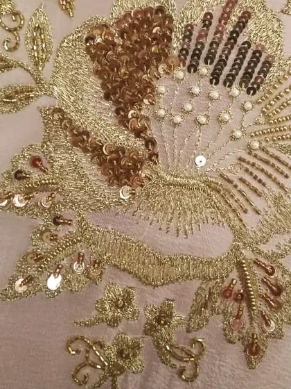 The details are where the magic happens. This is a close-up of a floral motif I created using a mix of gold threadwork, sequins, and delicate beads. This kind of hand embroidery makes each custom garment a piece of art.