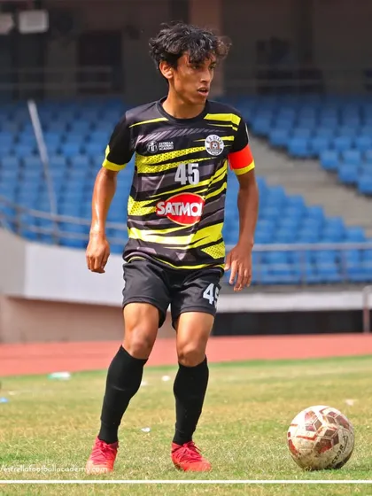 The team captain, wearing number 45, controls the ball and assesses his options during a competitive league game.