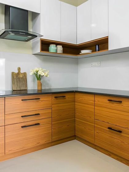 A beautiful example of a two-tone kitchen with natural wood grain lower cabinets and clean white upper cabinets. The handle-less design and black hardware create a modern and seamless look.