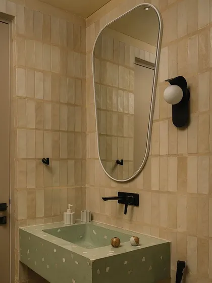 A bathroom we designed, featured by Kohler India. The green terrazzo sink adds a pop of color against the neutral, textured tiles.