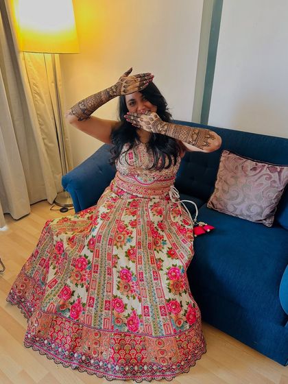 A playful pose from the bride, her hands framing her face to show off the intricate henna.