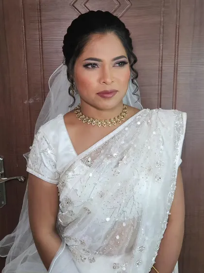 A beautiful Christian wedding look with a white saree. The makeup is soft and elegant, with a focus on her eyes.