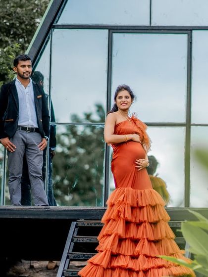 The Bronze gown against a modern, A-frame house. The dress's vibrant color and dramatic silhouette make it a standout choice for any location.