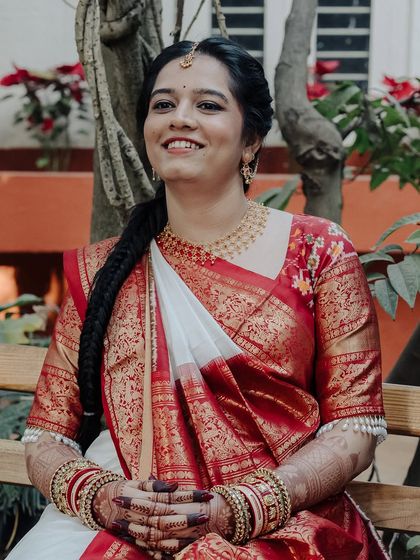 A candid, happy moment with a bride in a traditional red and white saree. Her genuine smile is everything.