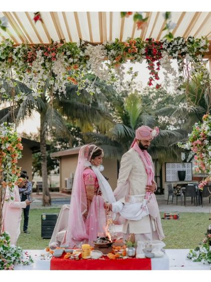 The couple taking their pheras around the sacred fire under a stunning floral mandap.