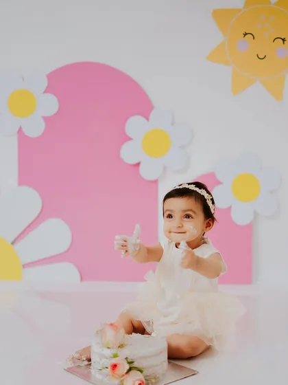 A sweet, smiling portrait amidst the fun. Even with cake on her hands, her happy personality shines through in this photo.