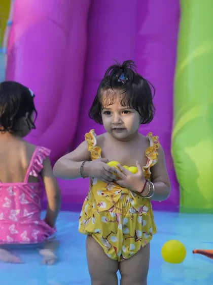 Two young children enjoying the splash pool. Our water play area is perfect for kids of all ages to cool off and have fun together.