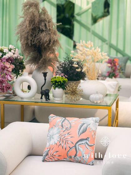 A close-up of a custom cushion with a monkey print, part of the playful and personal details of the baby shower.