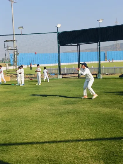 A female cricketer participates in a catching drill, showcasing our inclusive training environment where all players train together.