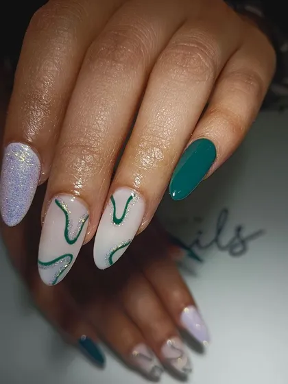 A different angle of this unique set, showing the abstract swirls and solid green nails from another perspective.