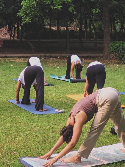Guiding my students through Parsvottanasana (Pyramid Pose) during an outdoor class. This hamstring stretch is excellent for improving flexibility in the legs and lower back.
