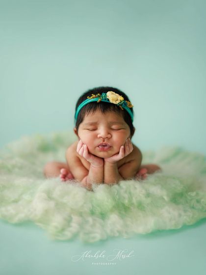 The "froggy" pose is a highly specialized and safe pose that I love to capture. It shows off the baby's sweet, squishy cheeks and curled-up nature beautifully.
