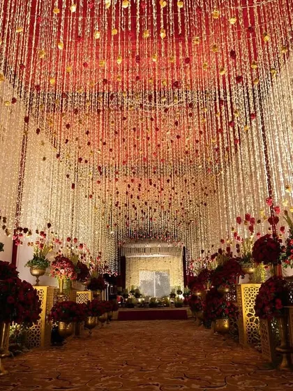 I believe a wedding entrance should be nothing short of breathtaking. For this Sufiyana-themed evening, I designed a grand walkway with thousands of suspended floral strings and traditional brass urns, creating a path that felt both royal and divine. This is how I set the stage for an unforgettable celebration.
