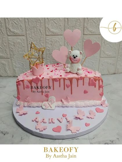 A beautiful "half way to one" celebration cake for a baby girl. This heart-shaped fresh fruit cake is decorated in shades of pink with a cute teddy bear.